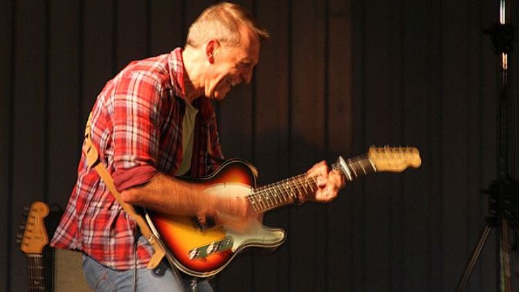 Gitarrist in rot kariertem Hemd beim Solo