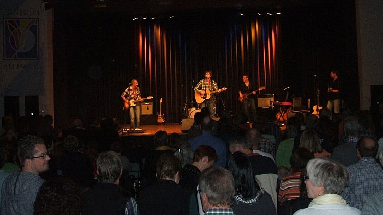 Konzertsaal mit Publikum, die Band auf der Bühne