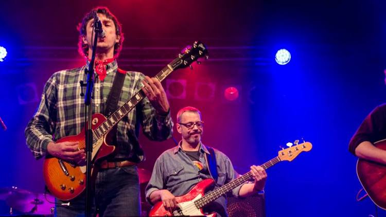 Sänger mit E-Gitarre am Mikrofon, daneben der Bassist