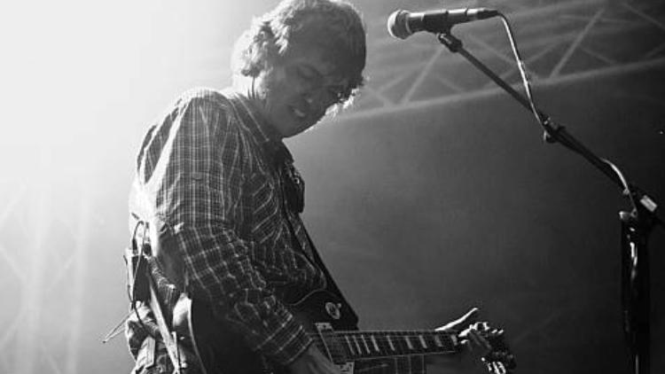 Sänger mit Gitarre am Mikrofon im Gegenlicht, Schwarzweißfoto