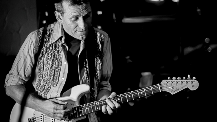 Gitarrist mit weißer E-Gitarre, Schwarzweißfoto