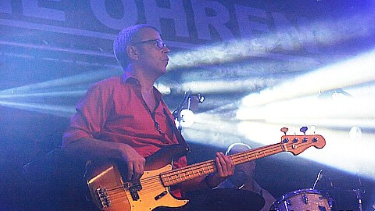 Bassist in rotem Hemd vor hellem Scheinwerferlicht